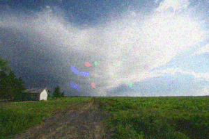 Multicolored dots and colored swirls cover a photo of a house in a field.