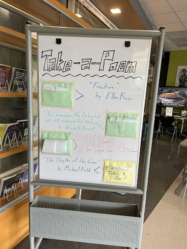 The Take-A-Poem Board in the LMC, a whiteboard with four poems available to take.